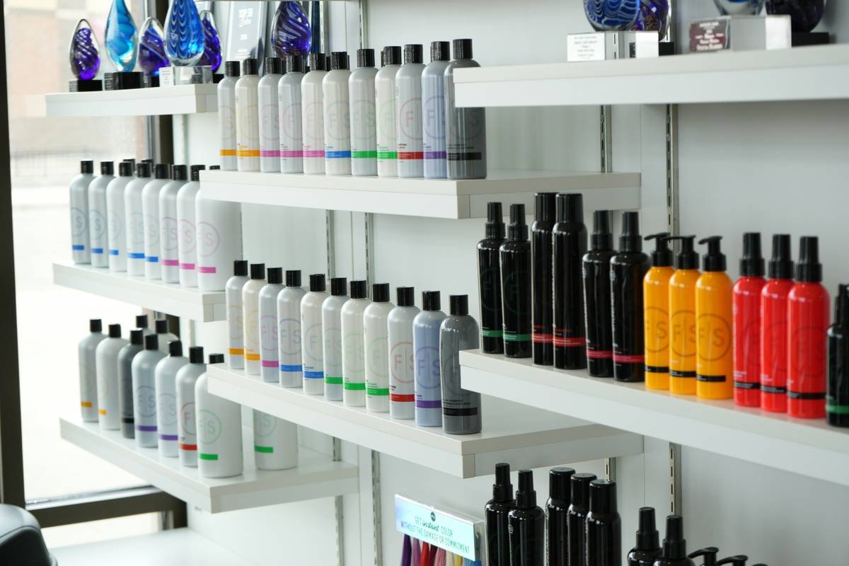 Infographic showing correct vs incorrect hair spray application with clips: spraying after placing clips causes slippage, while spraying before ensures grip